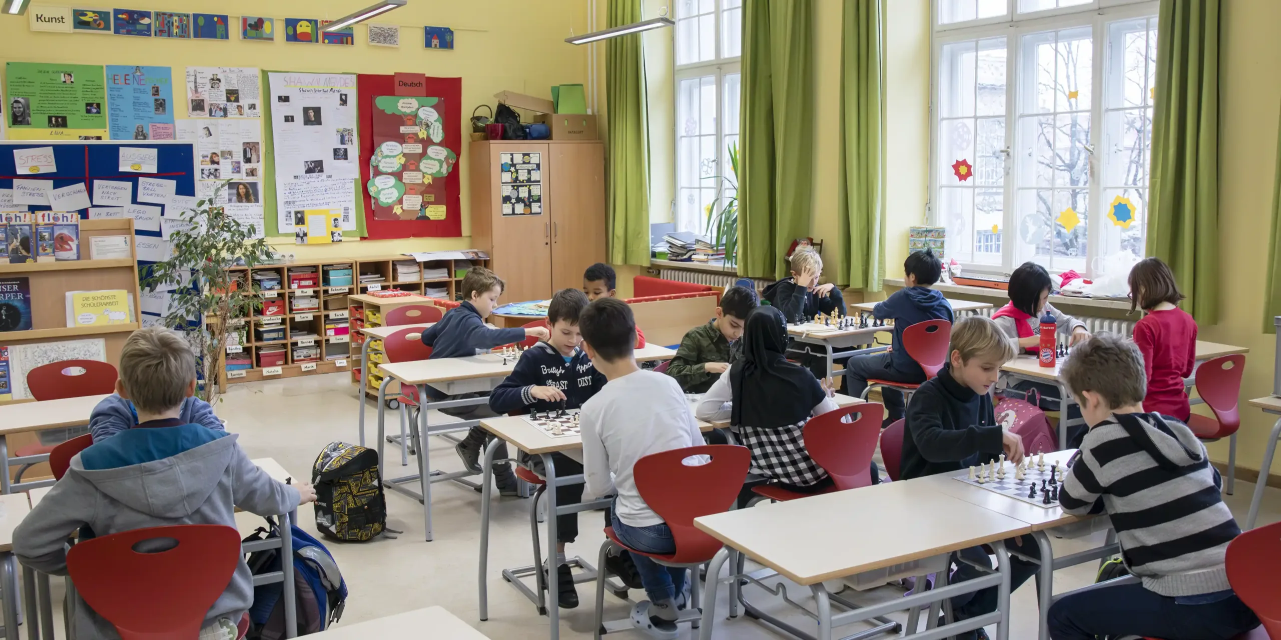 Farbfoto: Schulkinder im Hort einer Münchner Grundschule in der Schach-AG in einem Klassenzimmer