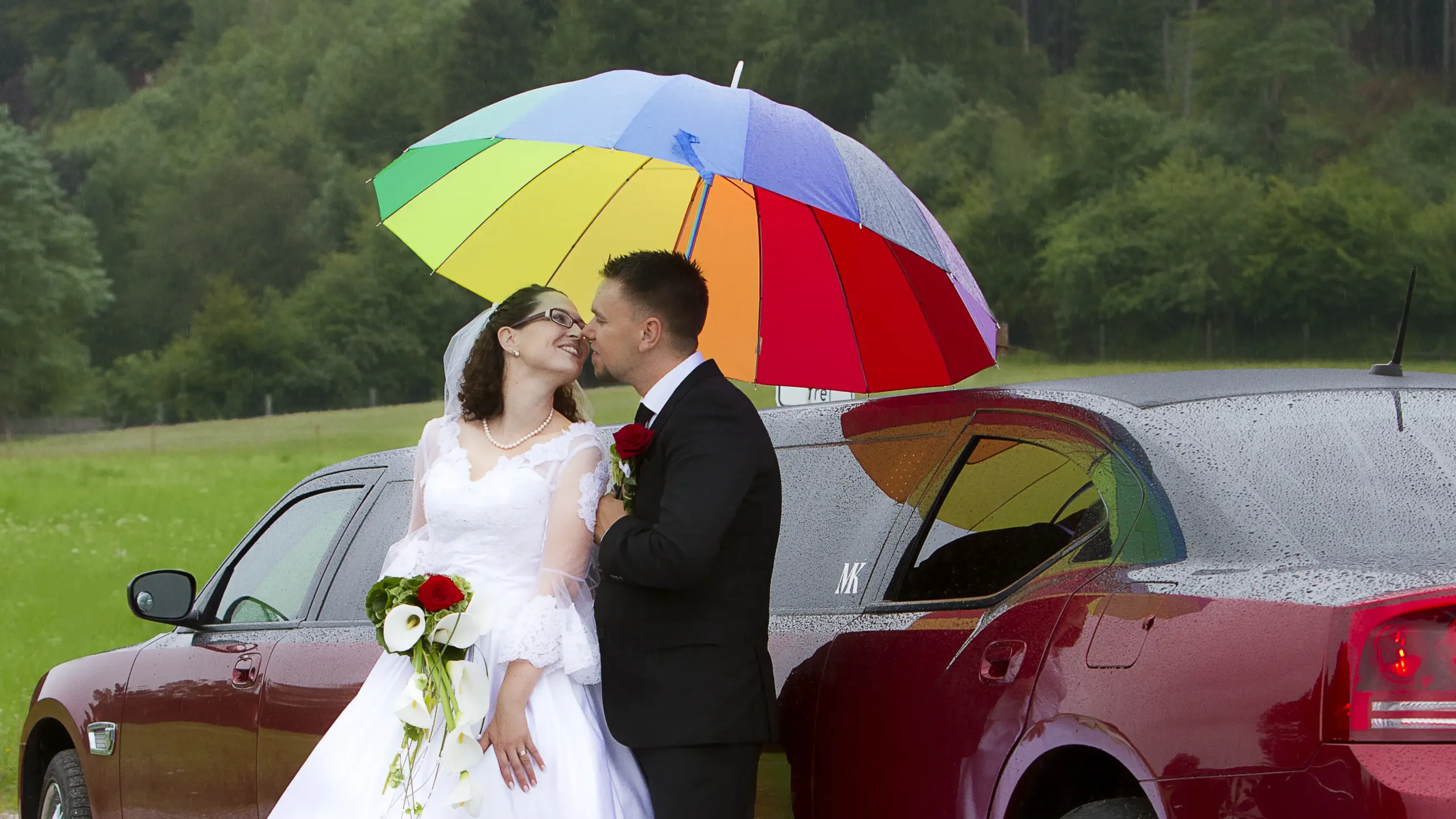 Hochzeit von Pamela und Kai im August - die Luxuslimousine und der Schirm schützen vor dem Regen